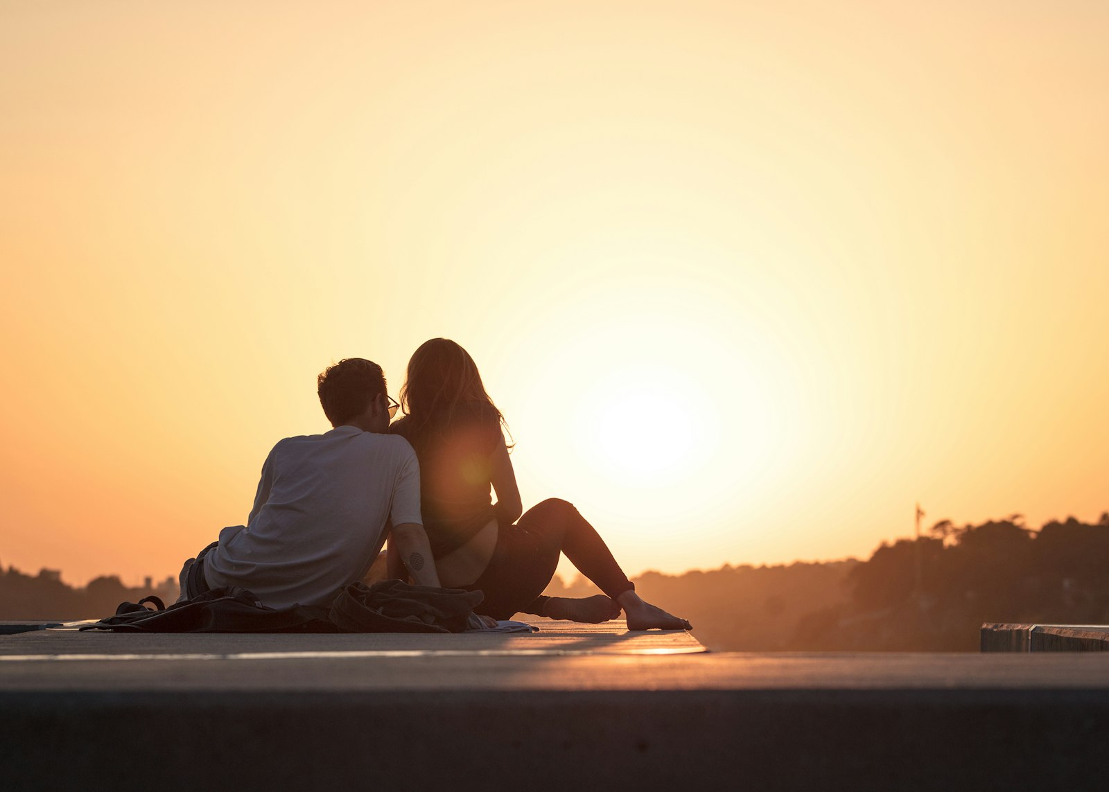 Two people sitting close together at golden hour